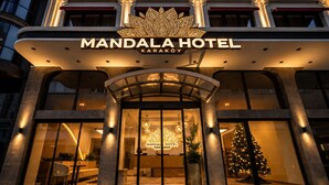 The exterior of Mandala Hotel with a prominent entrance, large windows, and a Christmas tree decoration. - Mandala Karaköy Hotel (Istanbul)