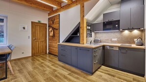 Una cocina moderna con armarios grises, encimera de madera y microondas integrado.