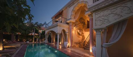 Vista frontal de la propiedad por la tarde o noche