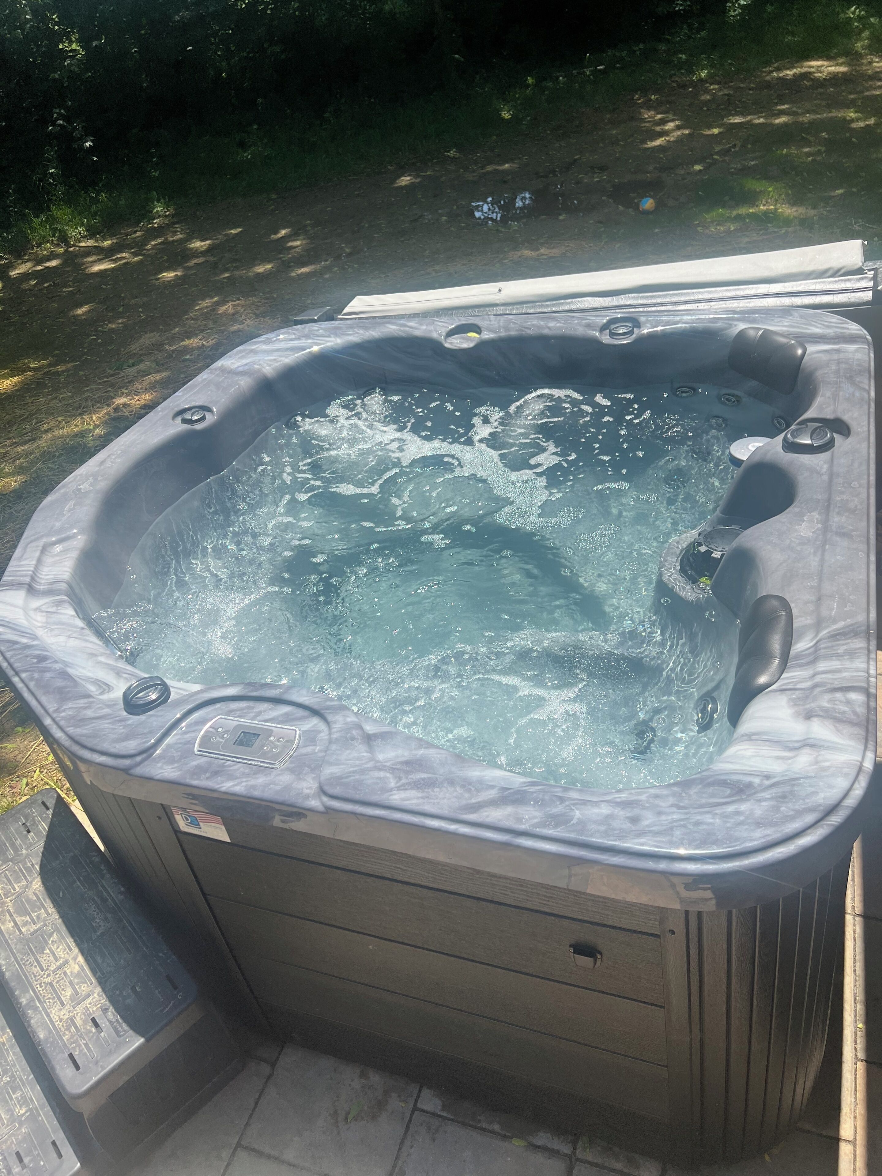 Ein Whirlpool mit Bedienfeld und einer Holzterrasse.