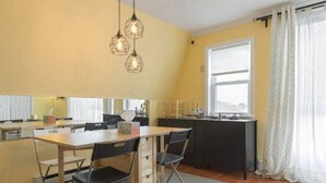 Une cuisine compacte avec une table à manger, des chaises et des luminaires suspendus.