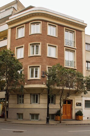 A multi-story building with a corner entrance, large windows, and a balcony. -  2-bedroom apartment in beautiful Lastarria Santiago (Santiago)