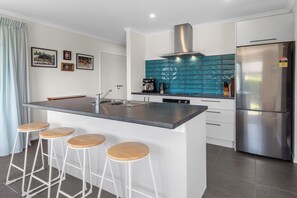 Enjoy cooking in this well-lit kitchen with a sleek island and stainless steel appliances.