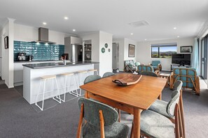 Enjoy a spacious living area with a dining table and comfortable seating, a well-equipped kitchen and a cozy seating area with a window offering a view.