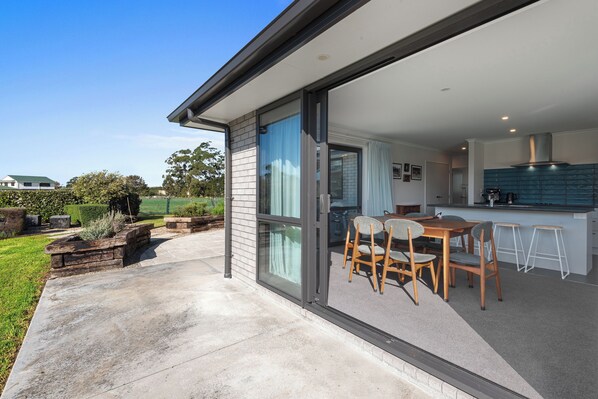 Enjoy the outdoors from the spacious patio with a comfortable seating area. The kitchen offers a functional space for cooking and entertaining.