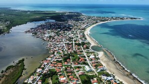 Vue aérienne d’une ville côtière avec une plage, des zones résidentielles et une rivière.