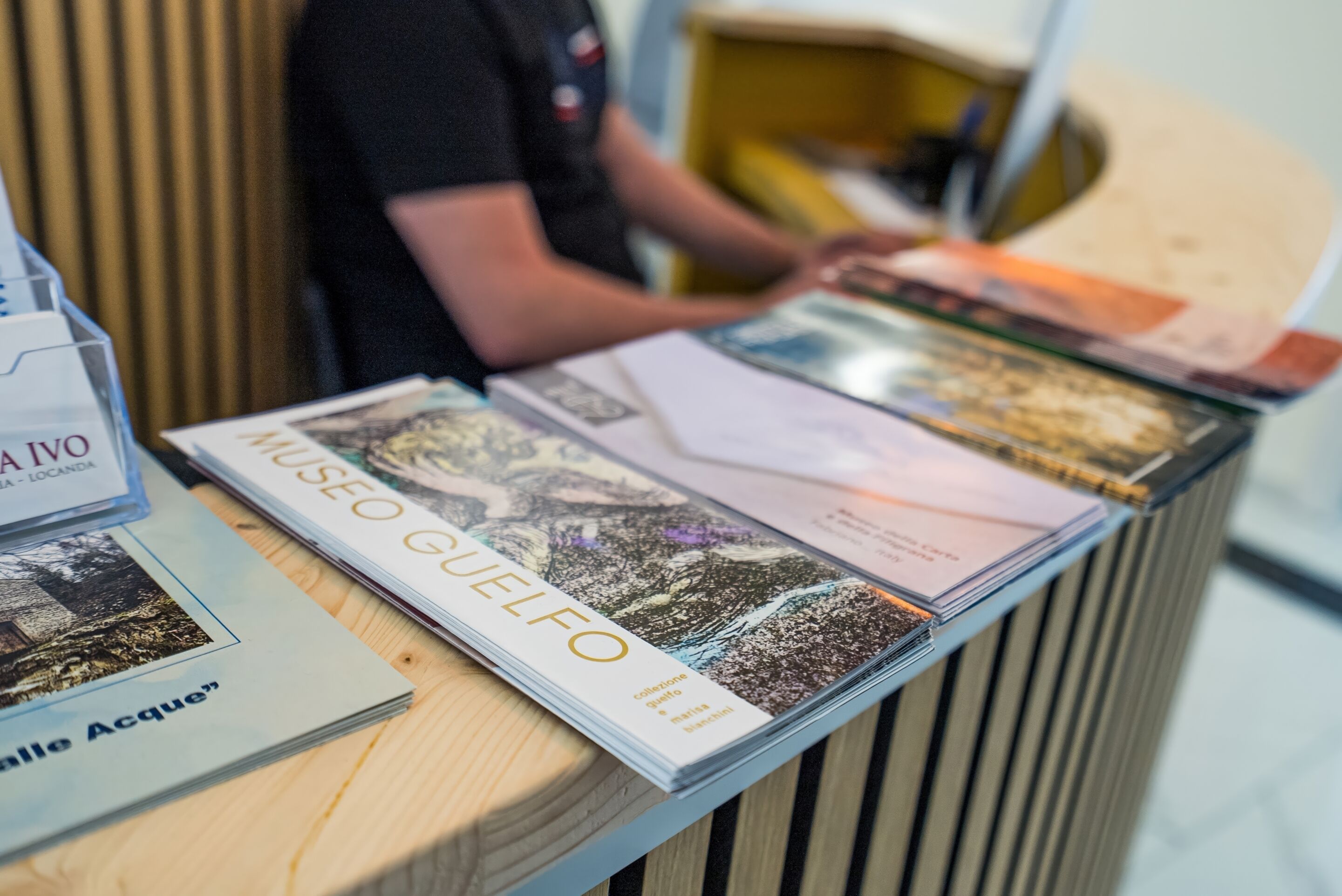 Una reception con una rivista intitolata 'MUSEO GUELFO' e del materiale informativo.