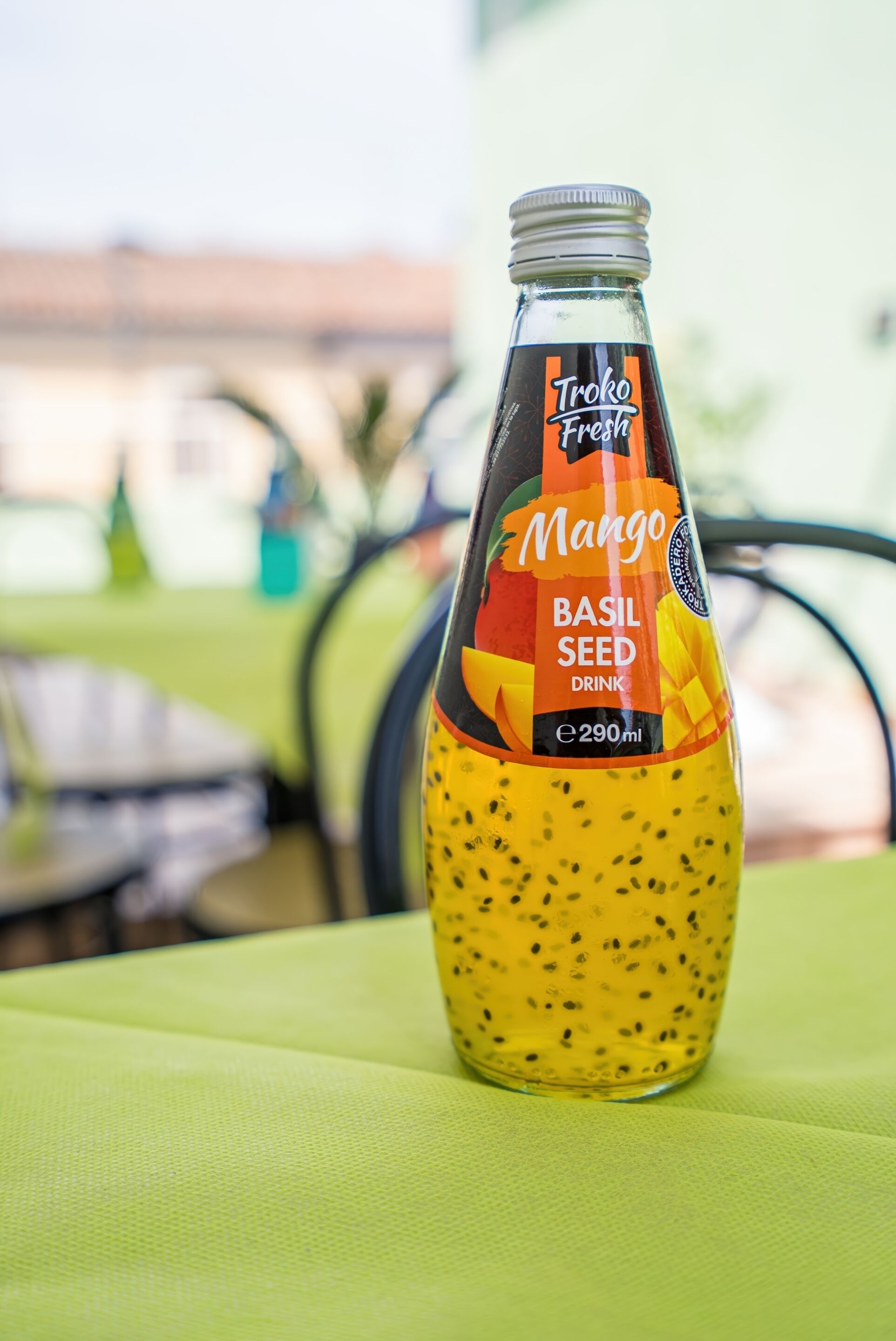 A bottle of Troke Fresh Mango Basil Seed Drink on a table.