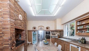 Enjoy cooking in this kitchen with a brick fireplace, island, and ample counter space.
