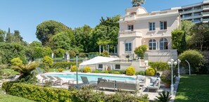 Relax by the pool surrounded by lush greenery and comfortable lounge chairs.
