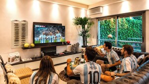 Una sala de estar con televisor, sofá y mesa de centro.