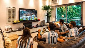 A living room with a television, a sofa, and a coffee table.