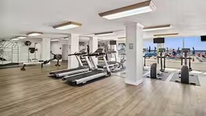 Un gimnasio con cintas de correr, bicicletas estáticas y máquinas de pesas.