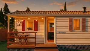 A single-story building with a covered patio, a dining area with a table and chairs, and a nameplate reading "RIVIERA". - Coastal Bloom Pool & Garden Stay  (Conil de la Frontera)