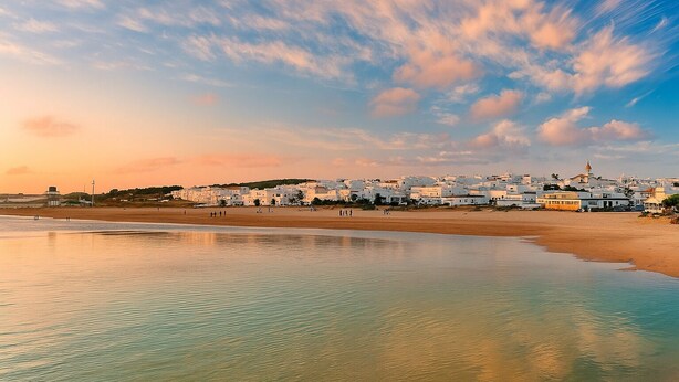 A coastal town with white buildings, a beach, and a clear sky with clouds. - Coastal Bloom Pool & Garden Stay  (Conil de la Frontera)