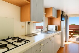 Full-size fridge, microwave, stovetop, cookware/dishes/utensils