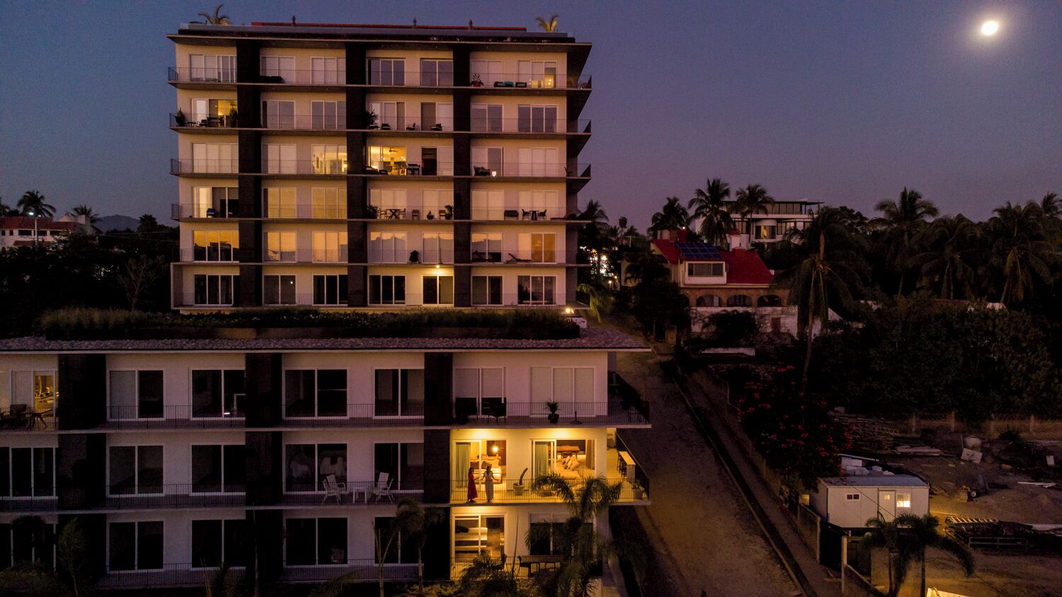 A multi-story hotel with balconies and a ground floor with a bar area.
