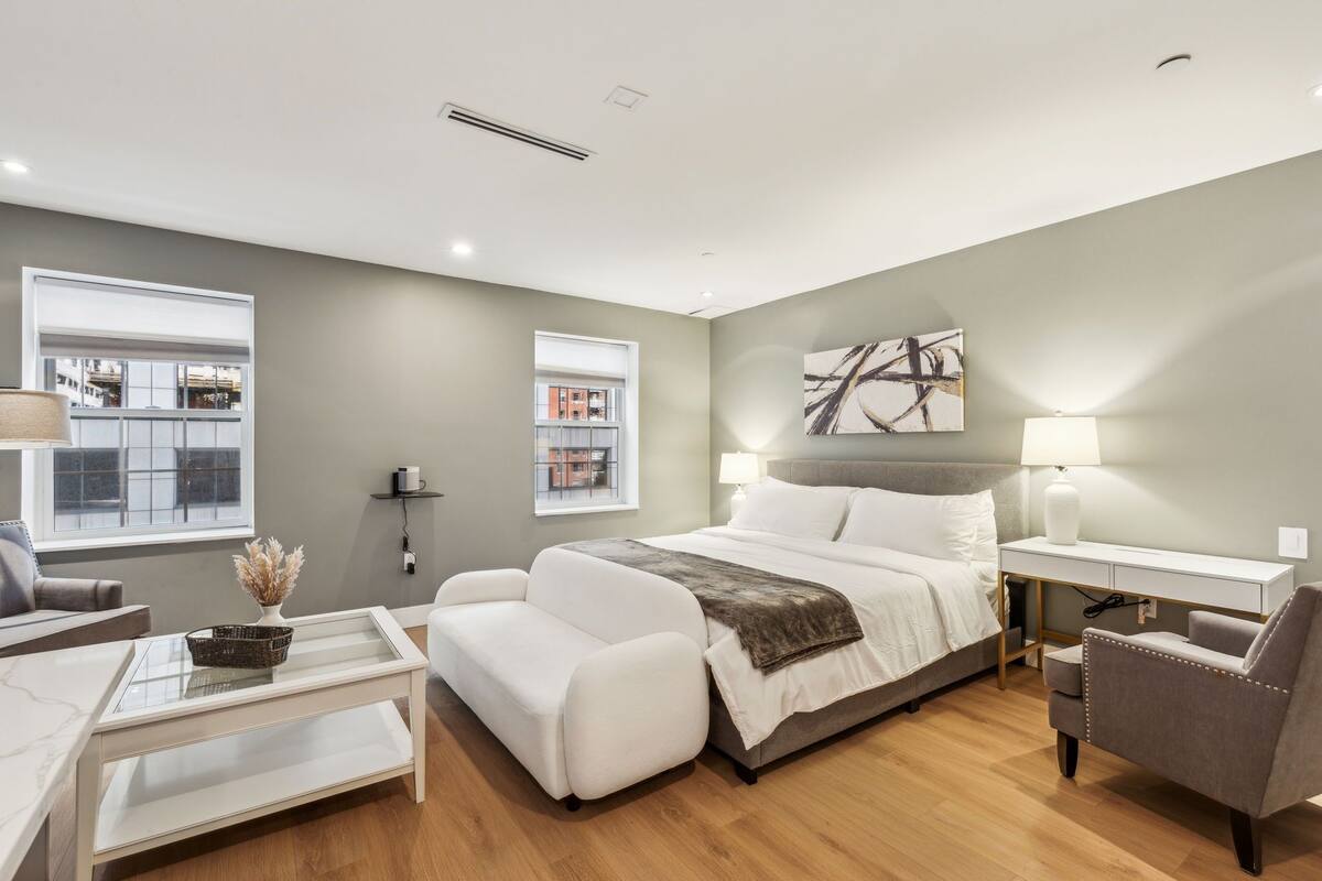 Un dormitorio moderno con una cama grande, un escritorio y un sofá.