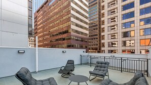 A rooftop terrace with modern outdoor seating and a view of surrounding high-rise buildings. - 24 Stay Rittenhouse (Philadelphia)
