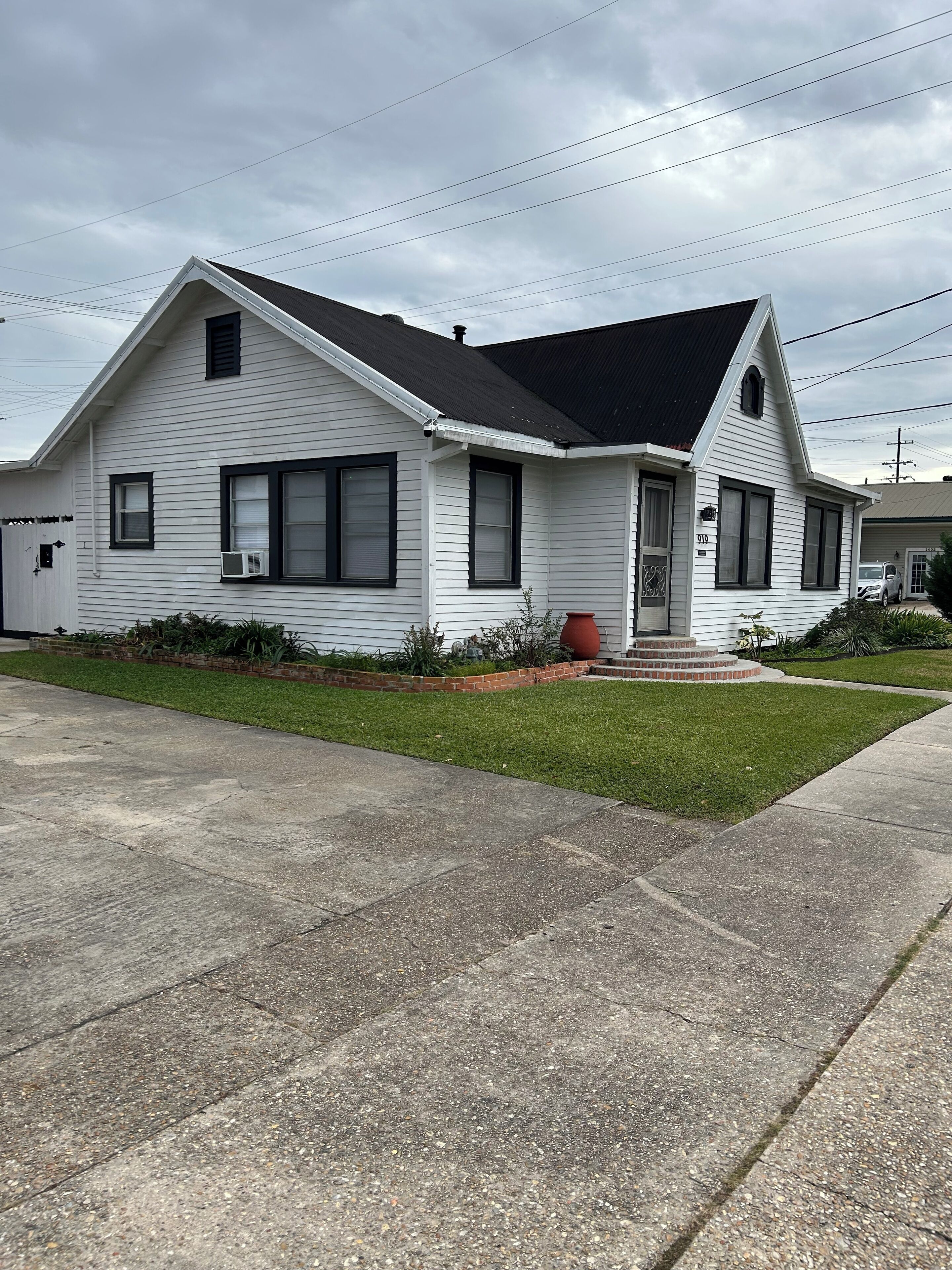 A single-story house with a gabled roof, a front porch, and a small front yard.
