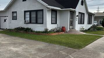 A single-story house with a gabled roof, a front porch, and a small front yard.