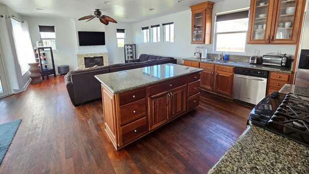 Una cocina amplia con armarios de madera, una isla con encimera de granito y horno empotrado.