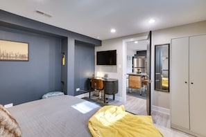 Relax in a spacious room with a large bed, flat-screen TV, and ample storage.