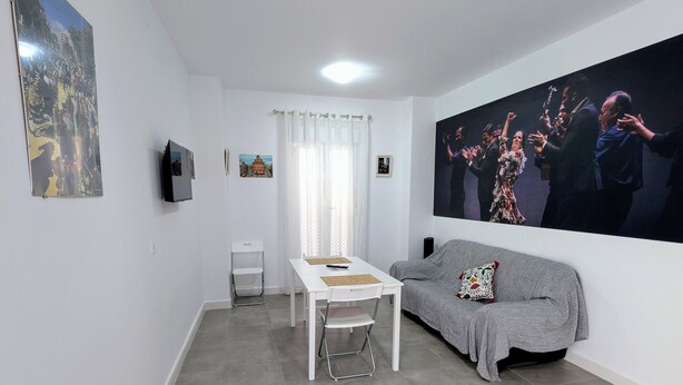 Un salon moderne avec une table à manger, un canapé et un grand tableau accroché au mur.