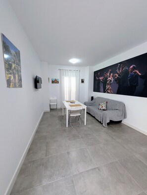 Apartamento conforto, vista para o pátio | Área de estar | Smart TV 32 polegadas com canais digitais, livros, serviços de streaming