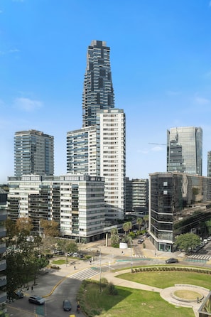 Un edificio de gran altura con un diseño retorcido único, rodeado de otros edificios modernos y un entorno urbano cuidado.