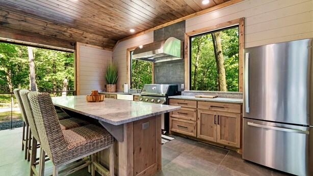 Una cocina moderna con armarios de madera, un refrigerador de acero inoxidable y una isla grande con asientos.