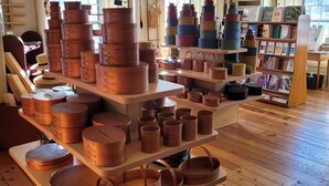 A room with wooden flooring and shelves displaying various copper pots and pans. - Enfield Shaker Museum (Enfield)