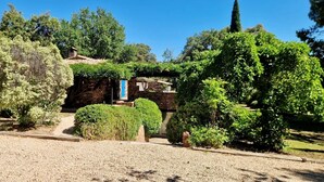 A garden with a stone building, gravel paths, and various shrubs. - Villa Rocks 3120 - A haven of peace at the foot of Roquebrune rock (Roquebrune-sur-Argens)