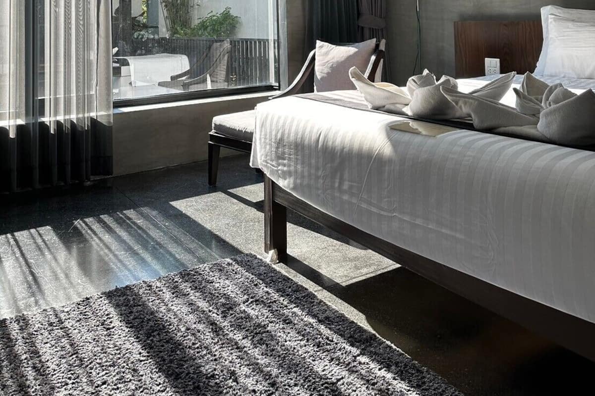 Ein modernes Hotelzimmer mit einem großen Bett, Blick ins Freie und einem kleinen Tisch.
