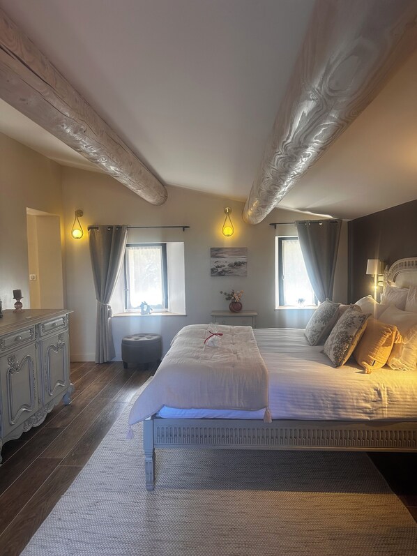 Un dormitorio con una cama grande, un aparador y una ventana con cortinas.