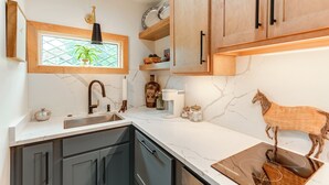 A kitchen with a marble countertop, wooden cabinets, a sink, and a decorative horse sculpture. - Boutique-Style Barn Stay 4 Mi to Franklin Main St (Franklin)