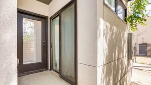 A modern building entrance with a glass door and a concrete exterior. - 2 Mi to Ball Arena: Townhome w/ Rooftop Patio (Denver)