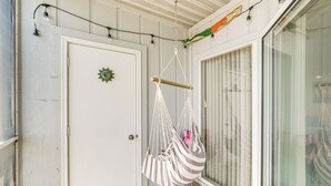 A room with a white door, a macrame hanging chair, and a large window with blinds. - 1 Mi to Ferry: Port Clinton Condo w/ Beach View! (Port Clinton)