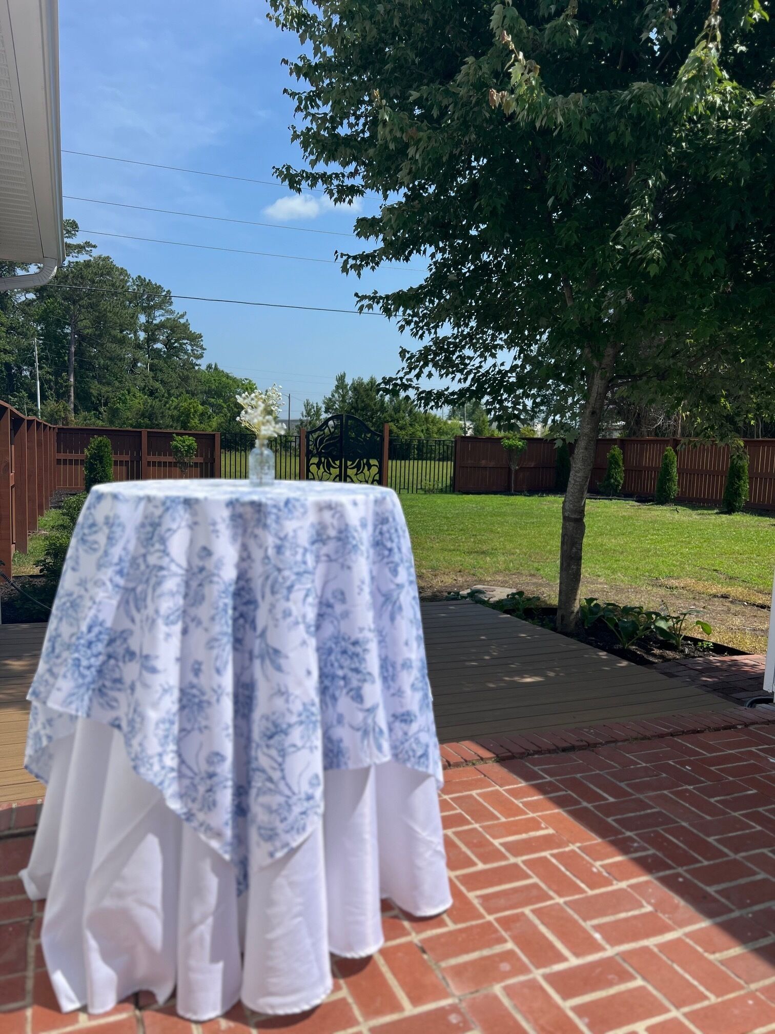 A patio with a table covered in a floral tablecloth.