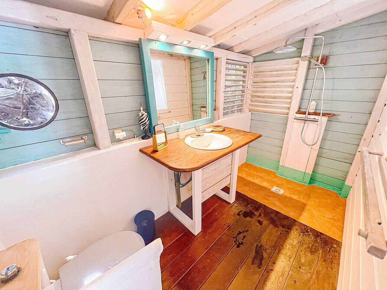 Une petite salle de bain avec un meuble-lavabo en bois, un lavabo blanc et un miroir.