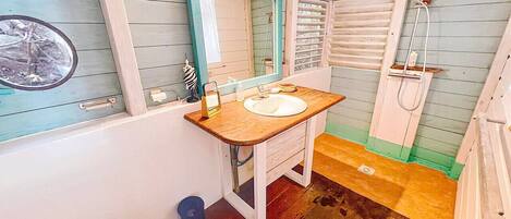Une petite salle de bain avec un meuble-lavabo en bois, un lavabo blanc et un miroir.