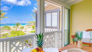 A balcony with a table set for breakfast, overlooking a beach and ocean view. - Villa Côté Sable, Accès plage, Vue mer, Elégance (Orient Bay)