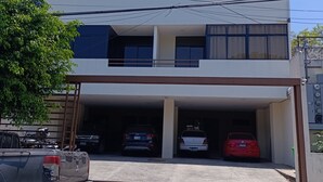A multi-story building with a garage parking area.