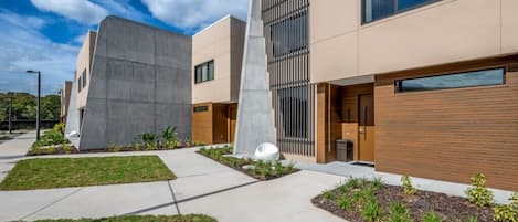 A modern building with a flat roof, large windows, and a concrete structure.