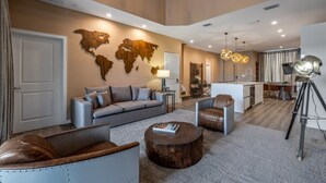 A modern living room with a grey sofa, a wooden coffee table, and a leather armchair. - Elegant Orlando Getaway Close to Disney (Kissimmee)