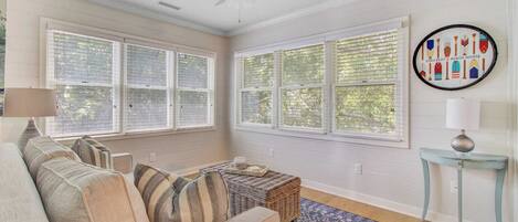 A cozy living room with a sofa, a small side table, and a decorative wall piece.