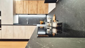 Eine moderne Küche mit schwarzem Marmorarbeitsplatz, Holzschränken und Edelstahlgeräten.