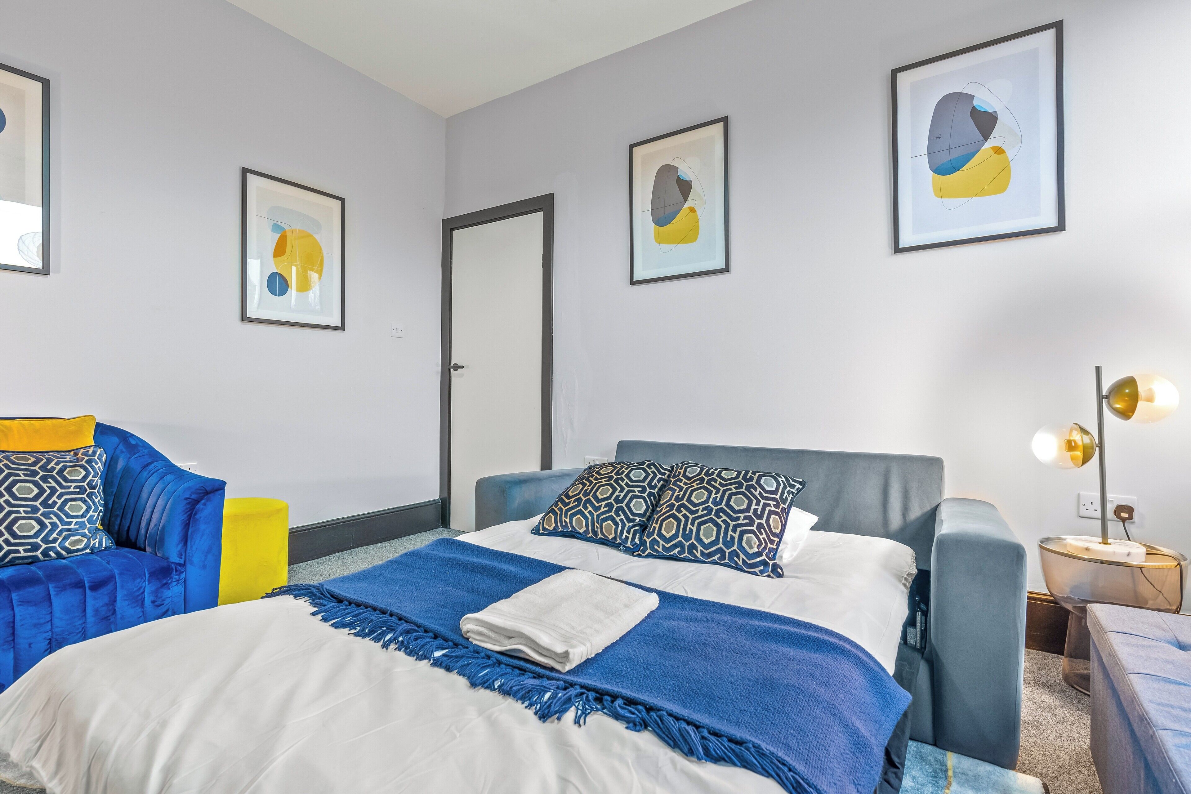 Une chambre d’hôtel moderne avec un lit, un canapé et une table de chevet.