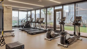 A modern gym with treadmills, elliptical machines, and a yoga mat area. - Luxe High Rise Near DT Austin w/ Views Rooftop Pool, Gym, & Luxe Amenities (Austin)
