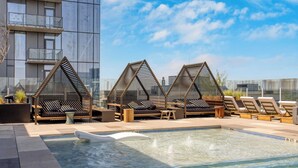 A rooftop pool area with lounge chairs and a modern building in the background. - Luxe High Rise Near DT Austin w/ Views Rooftop Pool, Gym, & Luxe Amenities (Austin)
